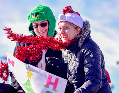two smiling students in christmas hats