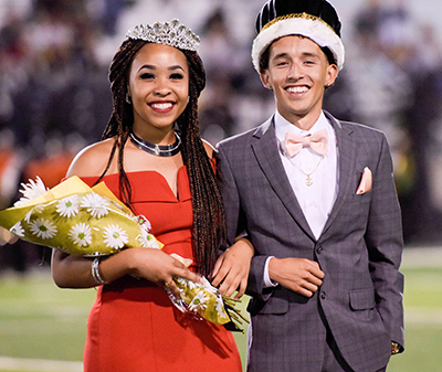 girl and boy smiling in with crowns