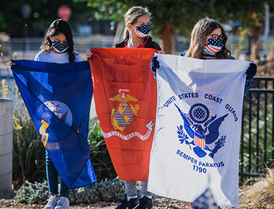 three students holding military flags