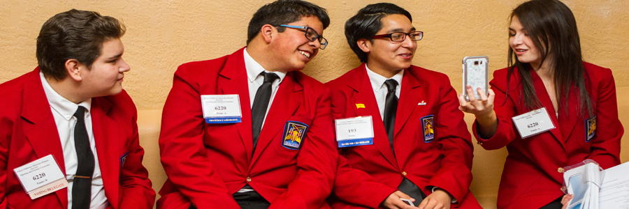 four skills usa students in red coats